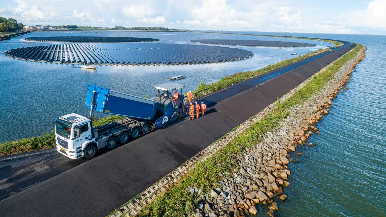 Het asfalteren van een dijk door wegenbouwers.
